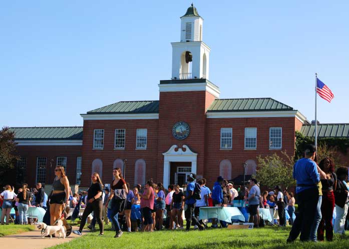 students on green lawn in front of beautiful building